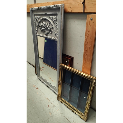 39 - A pier mirror with the relief frieze in silvered finish; a wall hanging display cabinet, gilt framed