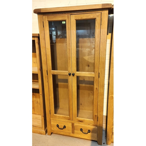 874 - A modern light oak full height display cabinet with 2 glazed doors and 2 small drawers