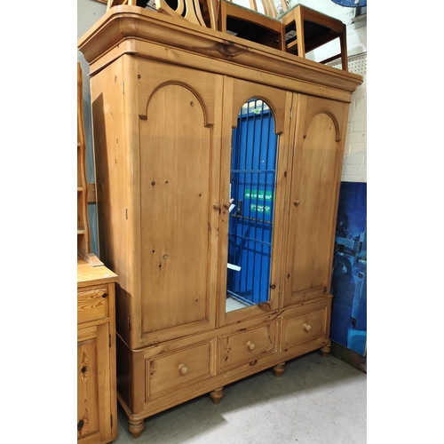 890 - A Victorian style pine triple wardrobe with central mirror and 3 base drawers