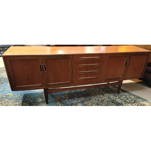 926 - A mid 20th century G-Plan teak long low sideboard with two double cupboards, three central drawers, ... 