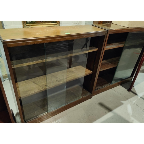 931 - A 1950's pair of 3 height walnut bookcases with sliding glass doors