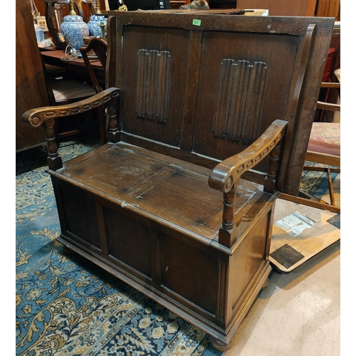 935 - A 1930's oak monks bench with linen fold decoration