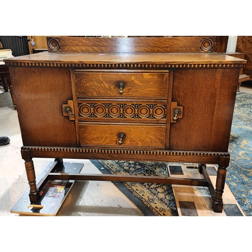 952 - A 1930's oak sideboard of 2 cupboards and 2 drawers