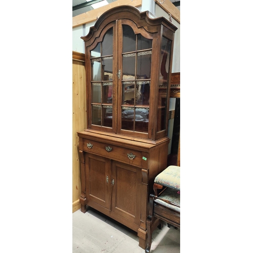 959 - An oak Arts & Crafts style full height bookcase with double astragal glazed doors and a double c... 