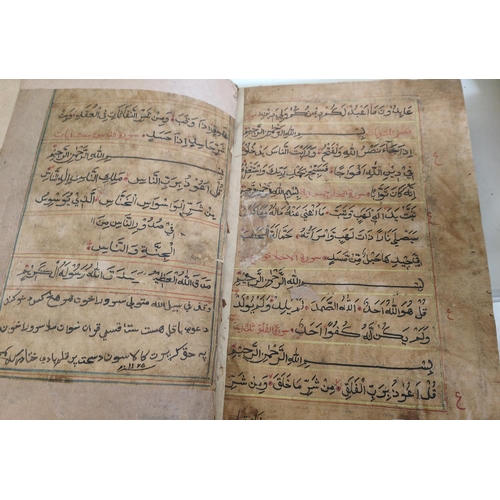 195E - A hand written Quran Arabic text backed onto later book, some text in borders (some moth damage)