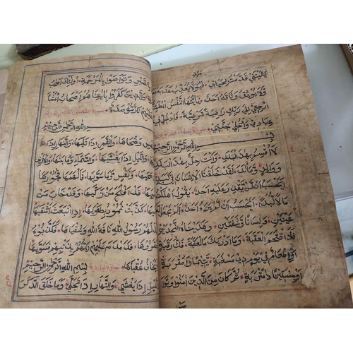 195E - A hand written Quran Arabic text backed onto later book, some text in borders (some moth damage)