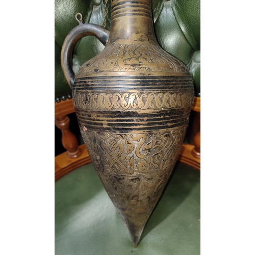 65 - An antique brass amphora etched with script around body