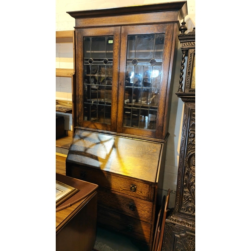 873 - An early 20th century Arts & Crafts style bureau/bookcase with coloured and leaded upper doors, ... 