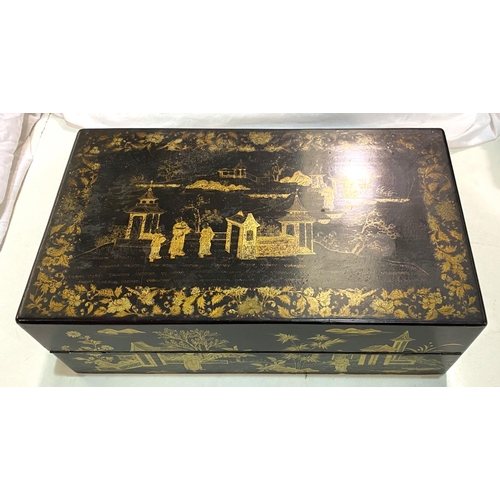 82 - A Japanese lacquer writing box with gilt decoration of pagodas and domestic scenes.