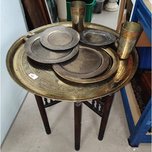 124 - A Middle Eastern circular folding table with etched decoration, similar brass including dishes, mugs... 