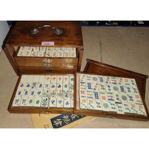 132 - An early/mid 20th century mah jong set with bone fascias in golden oak box