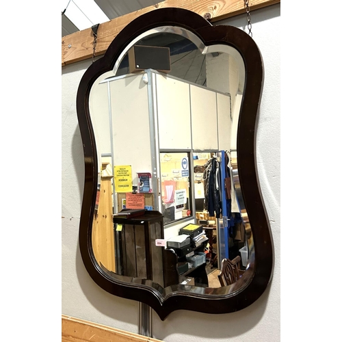 894 - A large wall mirror in shield shaped mahogany frame