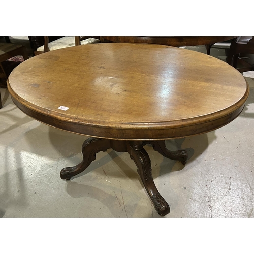 897 - A Victorian mahogany looe table with oval tilt top on 4 turned columns and 4 carved splay feet