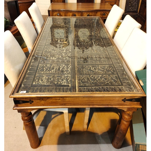 920 - An unusual dining table with carved African tribal panel under glass as table top, the panels having... 