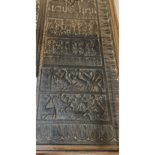 920 - An unusual dining table with carved African tribal panel under glass as table top, the panels having... 