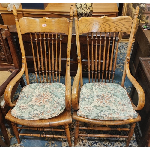 915 - A pair of golden oak spindle back armchairs with solid seats, two height stretchers