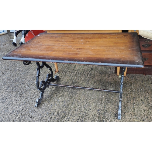 924 - A cast metal based pub table with stained wooden top, 120 x 70cm.