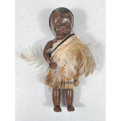 306A - A vintage plastic New Zealand Maori doll, 25cm, in a feathered cloak, 