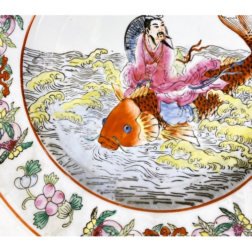 486A - A Chinese porcelain plate decorated with man astride a large carp, 25.5cm