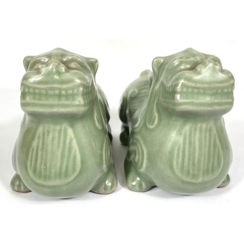 487A - A pair of Chinese celadon glaze candleholders in the form of Shi Shi, 13cm length 