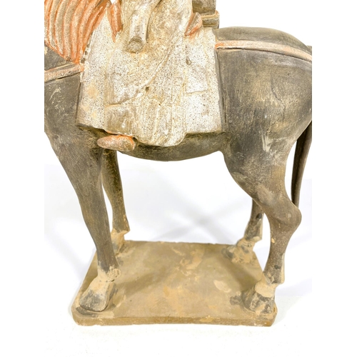 490 - A Chinese under glazed pottery figure on horseback, in the archaic style, painted decoration, 38cm h... 