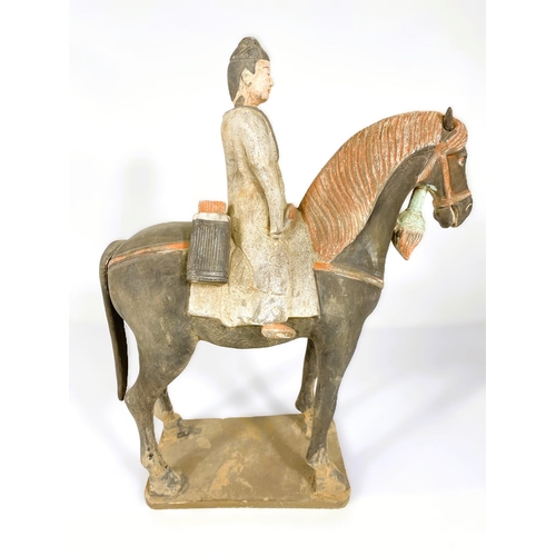 490 - A Chinese under glazed pottery figure on horseback, in the archaic style, painted decoration, 38cm h... 