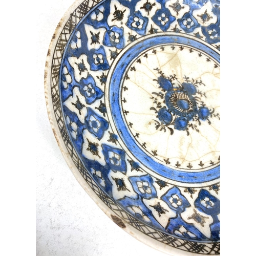 494B - An Islamic Iznik style dish with blue decoration on white glaze, dia. 24.5cm