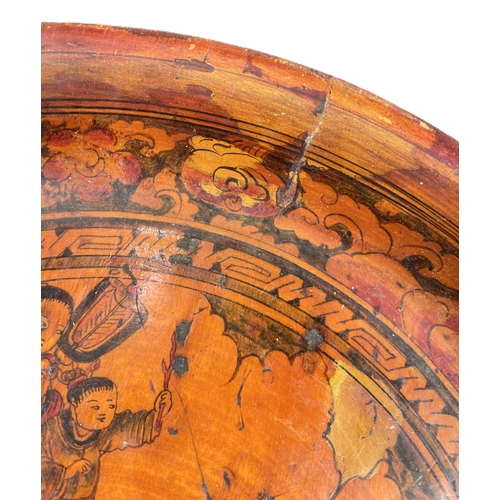 494C - An unusual 19th century Chinese wooden painted dish with figures among clouds (some cracking) 29cm