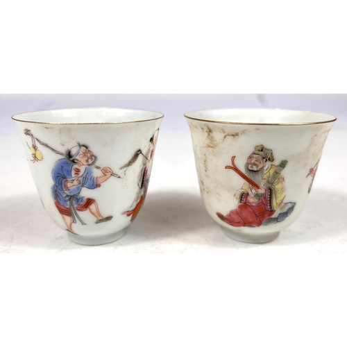 503 - A pair of Chinese famille rose wine cups decorated with deities to the outside, seal mark to base he... 