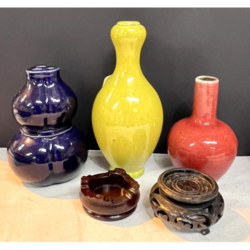 504A - Three small Chinese monochrome vases, yellow and red vases on stands and a dark blue double gourd va... 