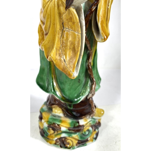 511B - A Chinese possibly Kangxi figure of a sage with bird and fruit, glazed in green, yellow and browns, ... 