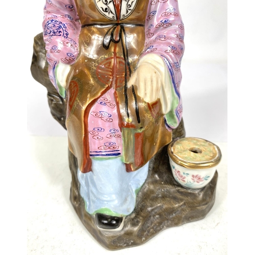 511C - A 20th century Chinese figure of an old man in well decorated clothing, impressed mark to base, ht. ... 