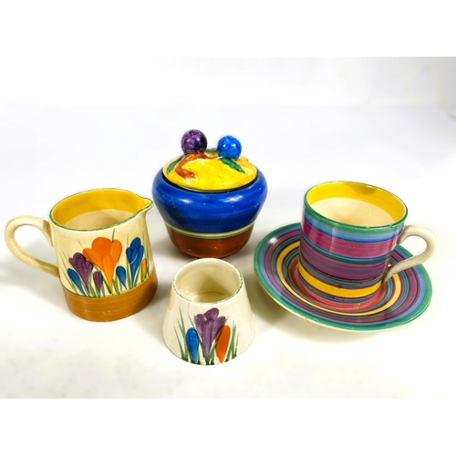 542 - A Clarice Cliff crocus pattern cream jug and egg cup; a coffee can and saucer with concentric colour... 