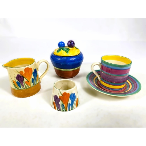 542 - A Clarice Cliff crocus pattern cream jug and egg cup; a coffee can and saucer with concentric colour... 