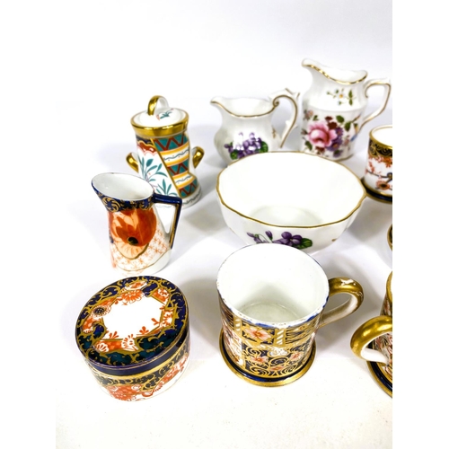 565 - A collection of miniature Royal Crown Derby pieces, cups & saucers, tyg, etc.