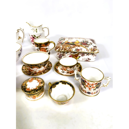 565 - A collection of miniature Royal Crown Derby pieces, cups & saucers, tyg, etc.