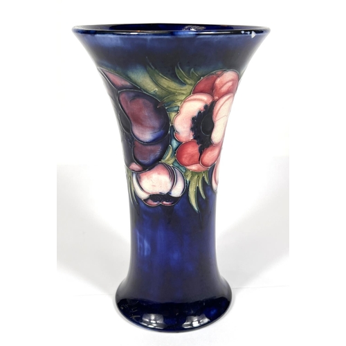 571 - Moorcroft: A William Moorcroft signed vase, dark blue ground with anemone flowers, waisted body with... 