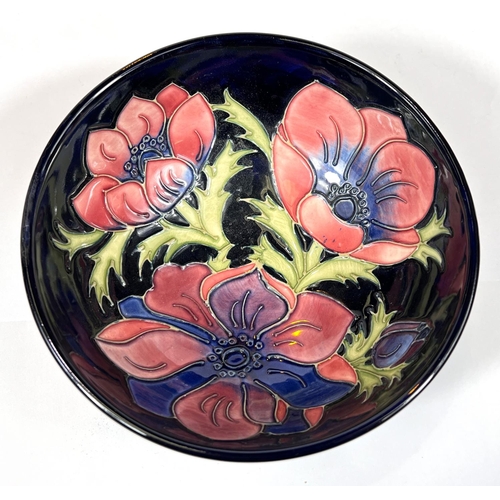 571A - Moorcroft: A modern Moorcroft bowl with dark blue ground anemone decoration, signed JW WM beneath, d... 