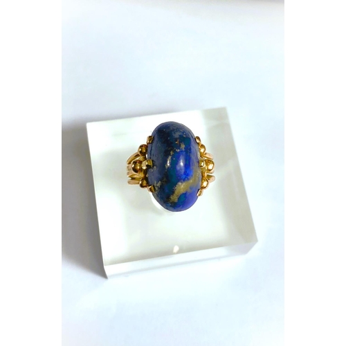 608 - A yellow metal dress ring set yellow seamed lapis lazuli coloured stone, Egyptian marks to shank, 5.... 