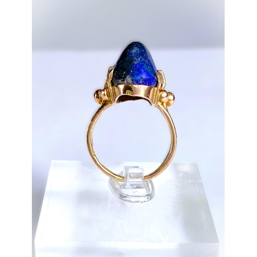 608 - A yellow metal dress ring set yellow seamed lapis lazuli coloured stone, Egyptian marks to shank, 5.... 