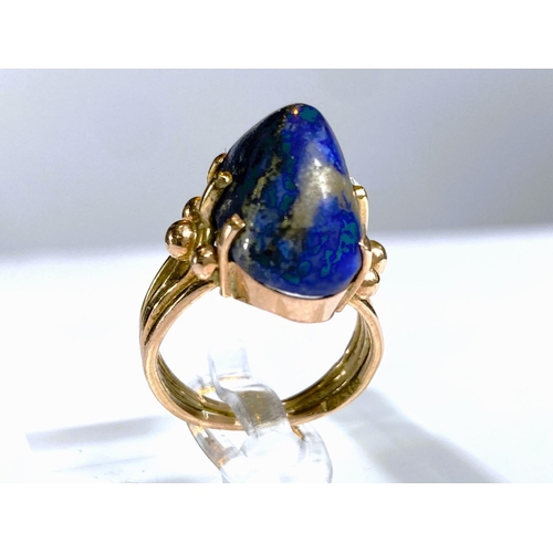 608 - A yellow metal dress ring set yellow seamed lapis lazuli coloured stone, Egyptian marks to shank, 5.... 