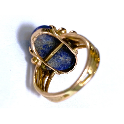 608 - A yellow metal dress ring set yellow seamed lapis lazuli coloured stone, Egyptian marks to shank, 5.... 