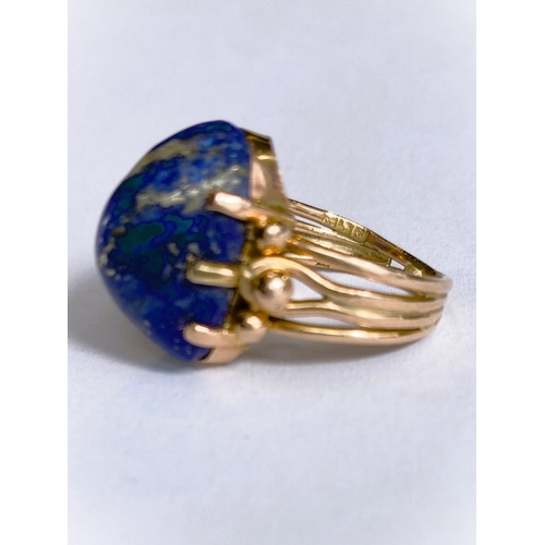 608 - A yellow metal dress ring set yellow seamed lapis lazuli coloured stone, Egyptian marks to shank, 5.... 