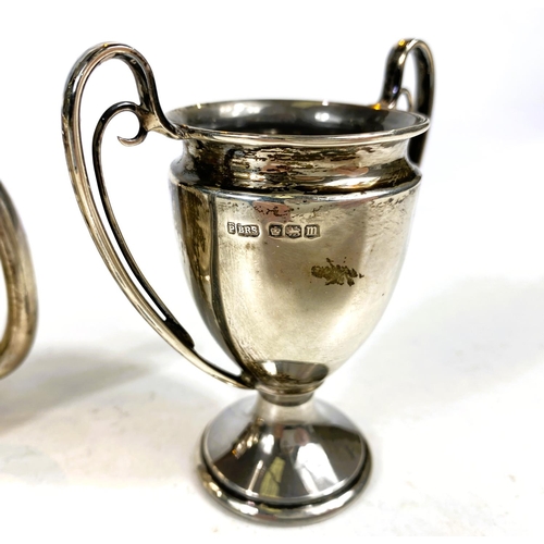 631 - Four hallmarked silver items:  a 2-handled trophy cup; a christening mug; a small trophy cup; a... 