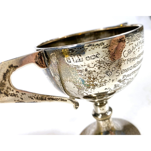 631 - Four hallmarked silver items:  a 2-handled trophy cup; a christening mug; a small trophy cup; a... 