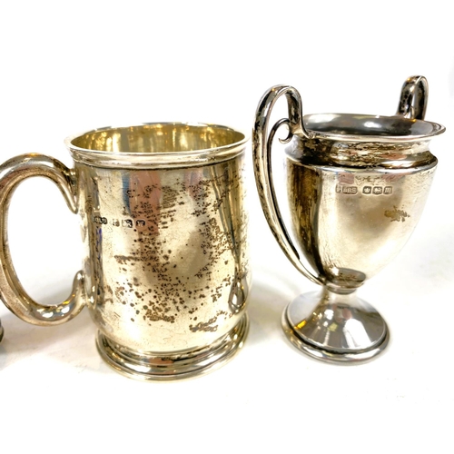 631 - Four hallmarked silver items:  a 2-handled trophy cup; a christening mug; a small trophy cup; a... 