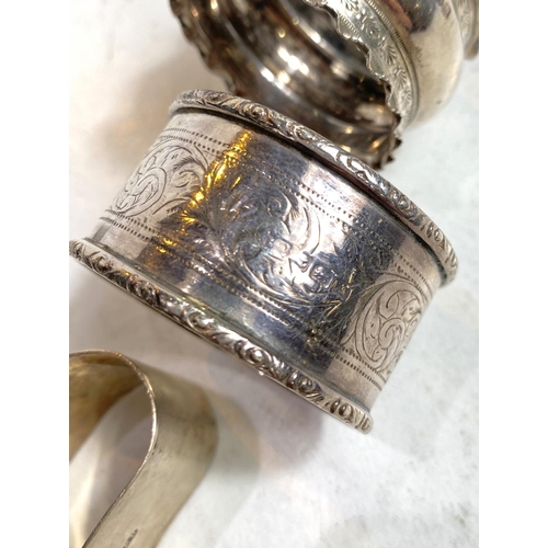 632 - Seven hallmarked silver assorted napkin rings, 4.25oz; a white metal napkin ring