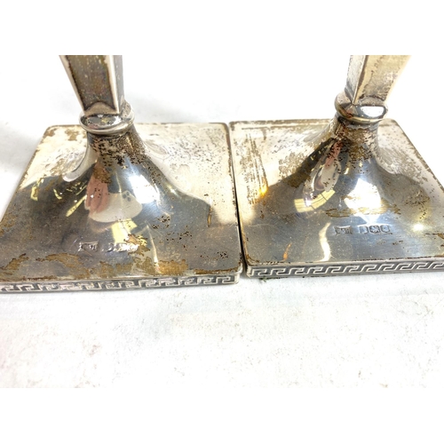 634 - A hallmarked silver pair of candlesticks with square tapering columns on square weighted bases, Shef... 