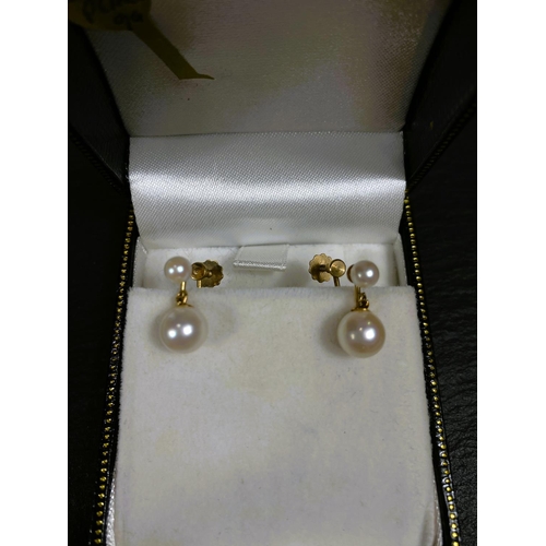 657 - A yellow metal pair of screw earrings, each set with a large and small cultured pearl; a similar pai... 