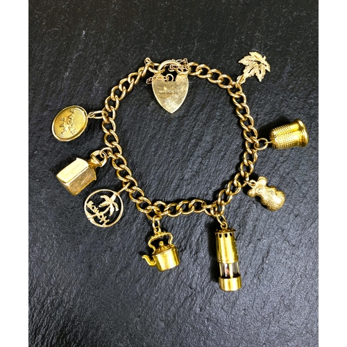 667 - A yellow metal charm bracelet, stamped 375, with heart lock and 7 charms (4 unmarked), gross weight ... 